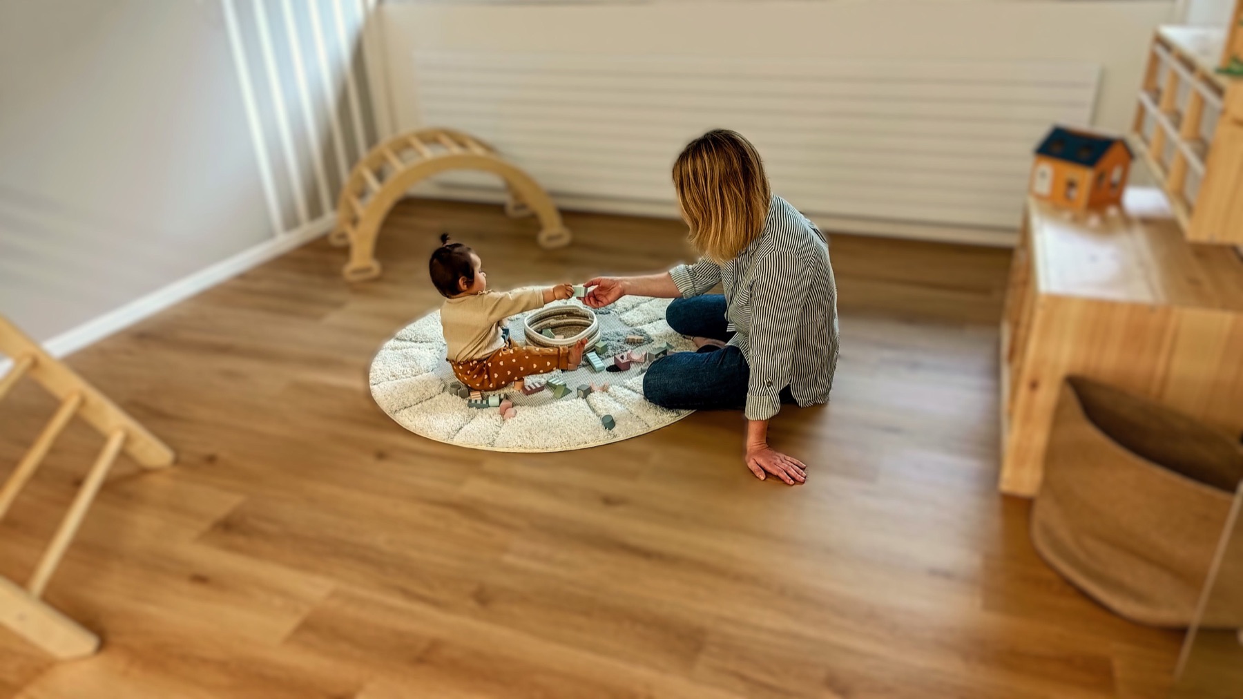 Betreuerin spielt liebevoll mit einem Baby in der Kita Liebeskind Basel