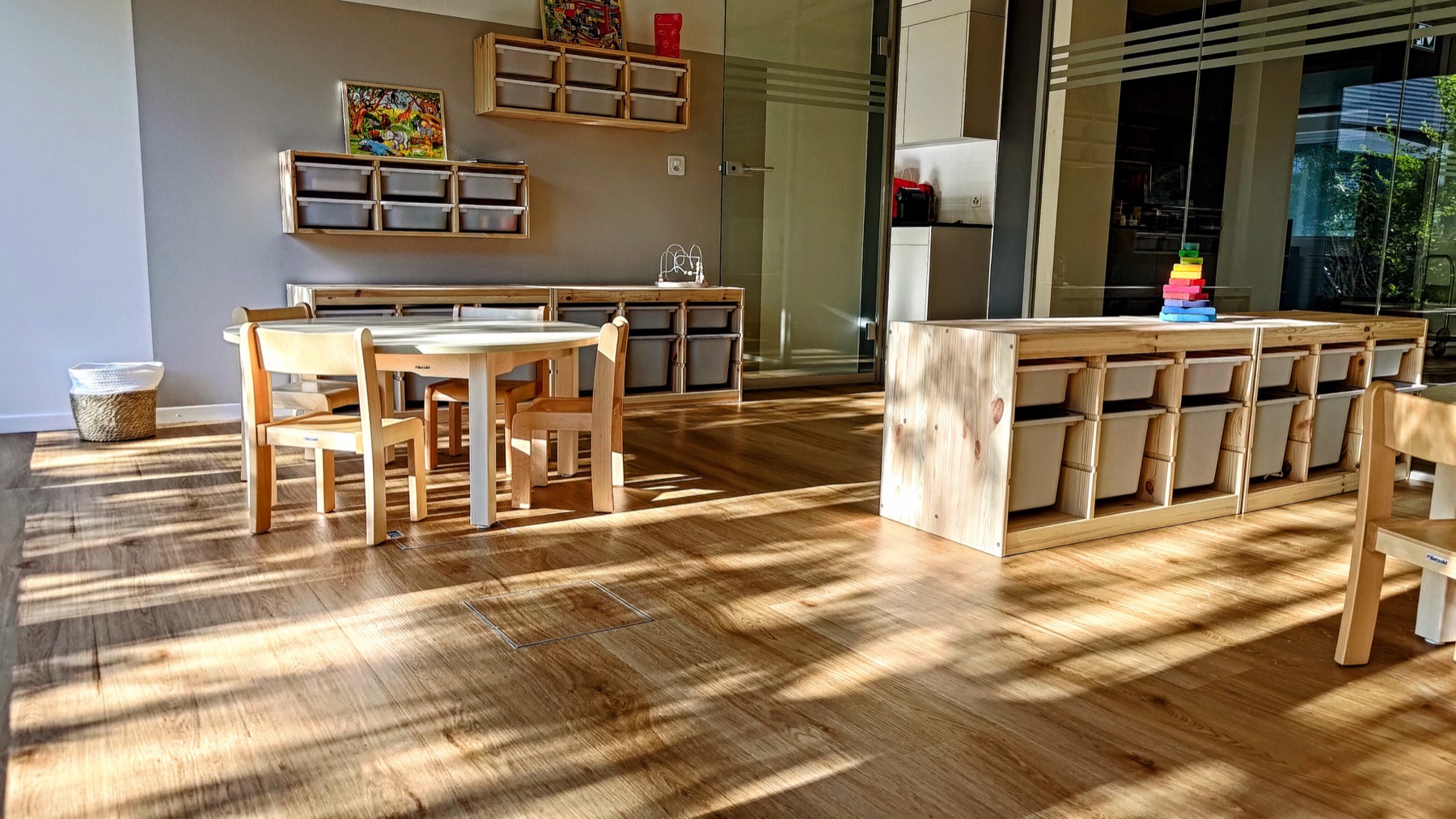 Sonniger Gruppenraum mit Kindertischen